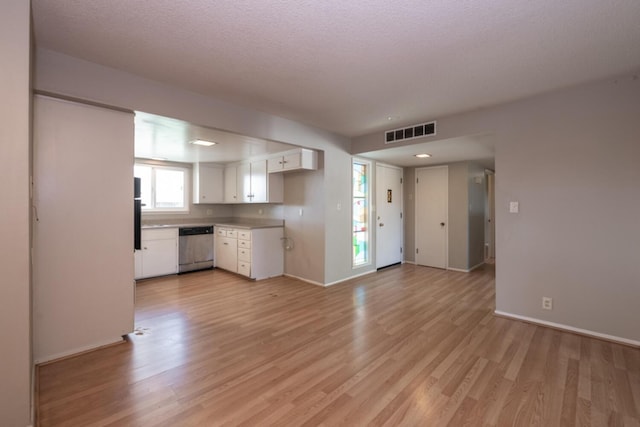 kitchen featuring white cabinets, visible vents, light wood-style flooring, and stainless steel dishwasher