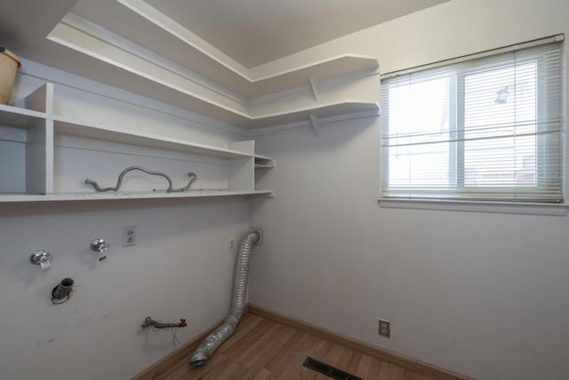 laundry room featuring laundry area, baseboards, visible vents, gas dryer hookup, and wood finished floors