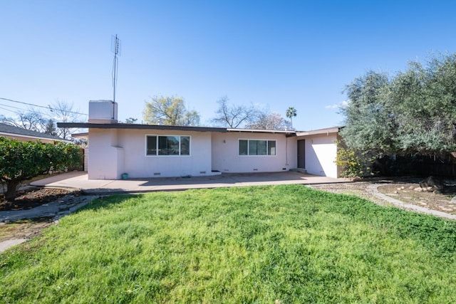 rear view of property featuring a patio area and a lawn