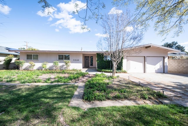 single story home featuring a front yard, driveway, an attached garage, and fence