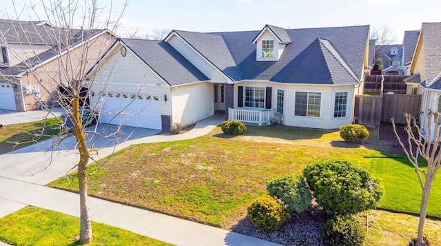 view of front of house featuring a garage, driveway, a front yard, and fence