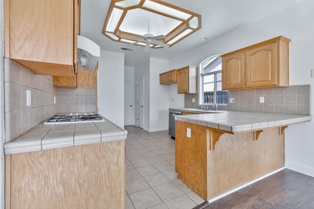 15877 W C St, Kerman, CA 93630 - kitchen with gas cooktop, extractor fan, tile countertops, dishwasher, and a peninsula