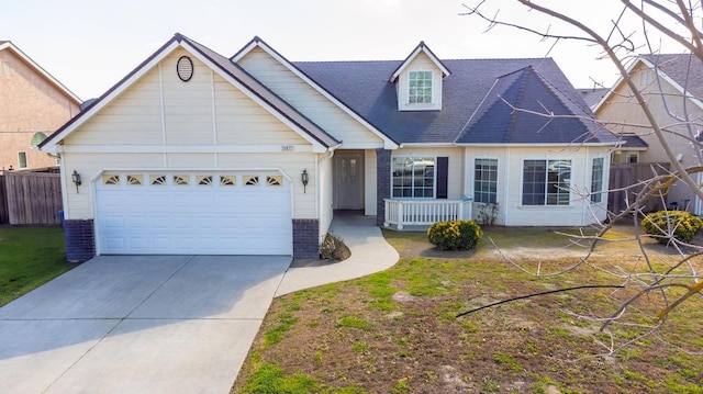 view of front of house with an attached garage, fence, concrete driveway, and brick siding