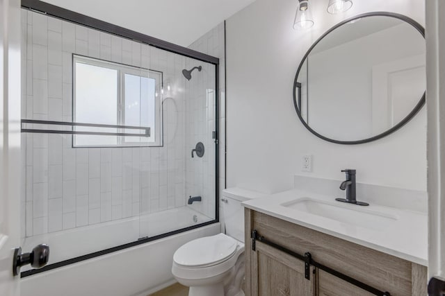 bathroom with enclosed tub / shower combo, vanity, and toilet