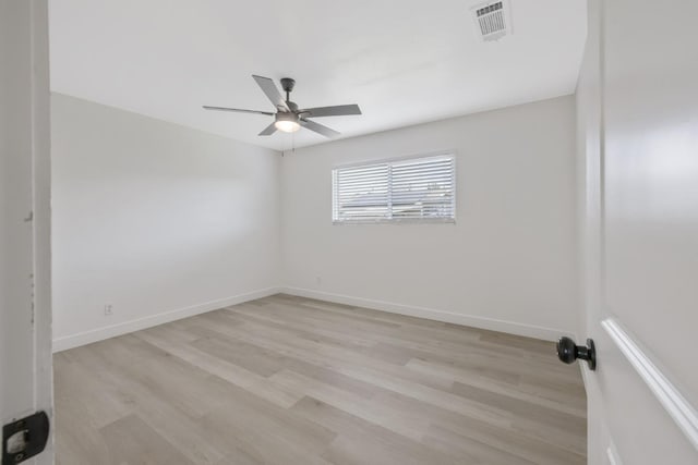 unfurnished room with ceiling fan, light wood finished floors, visible vents, and baseboards