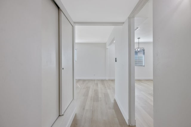 hall featuring baseboards and light wood-style floors