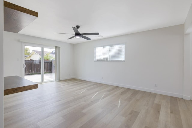 empty room featuring light wood finished floors, baseboards, visible vents, and ceiling fan