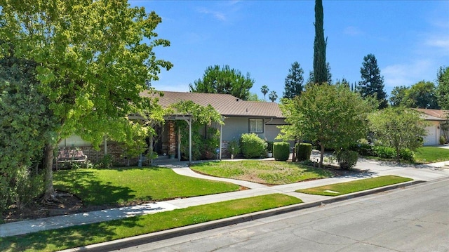 view of property hidden behind natural elements with a garage, driveway, and a front yard