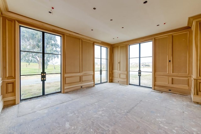 empty room featuring crown molding and a decorative wall