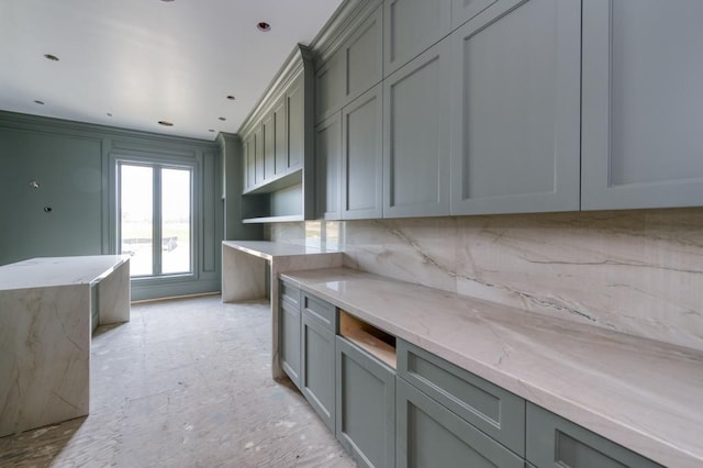 kitchen with tasteful backsplash, gray cabinets, and light stone counters