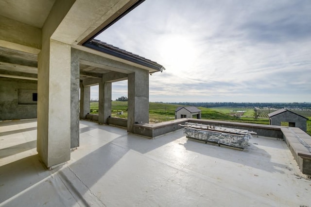 view of patio featuring an outdoor structure, a fire pit, and a storage unit