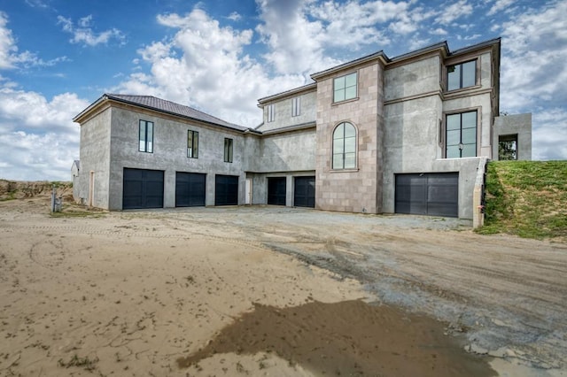 view of front of home featuring driveway, stone siding, and an attached garage