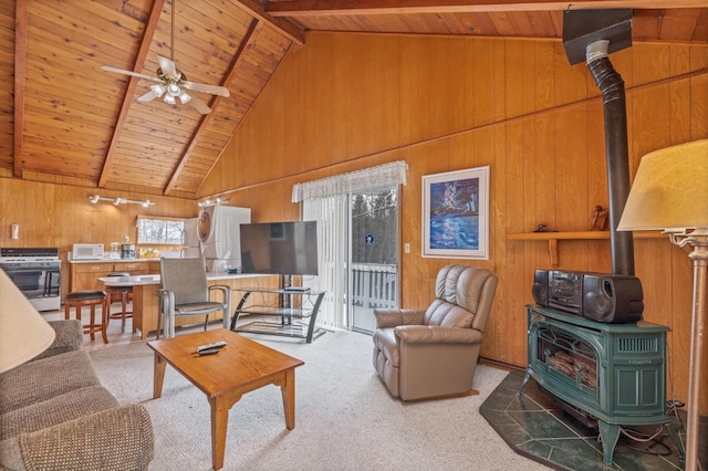 39118 Lake Dr, Bass Lake, CA 93604 - living area featuring a wood stove, a wooden ceiling with exposed beams, high vaulted ceiling, wooden walls, and ceiling fan