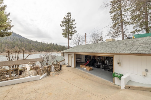 39118 Lake Dr, Bass Lake, CA 93604 - view of property exterior featuring a shingled roof, an outbuilding, and a mountain view