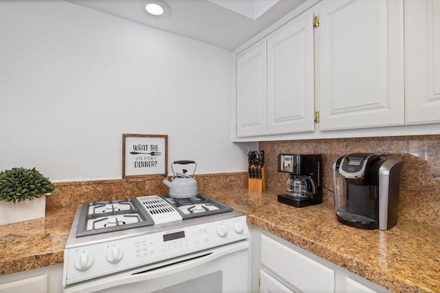 39118 Lake Dr, Bass Lake, CA 93604 - kitchen featuring white gas range, white cabinetry, and tasteful backsplash