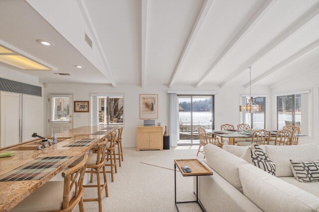 39118 Lake Dr, Bass Lake, CA 93604 - living room with light carpet, beam ceiling, a chandelier, recessed lighting, and a water view