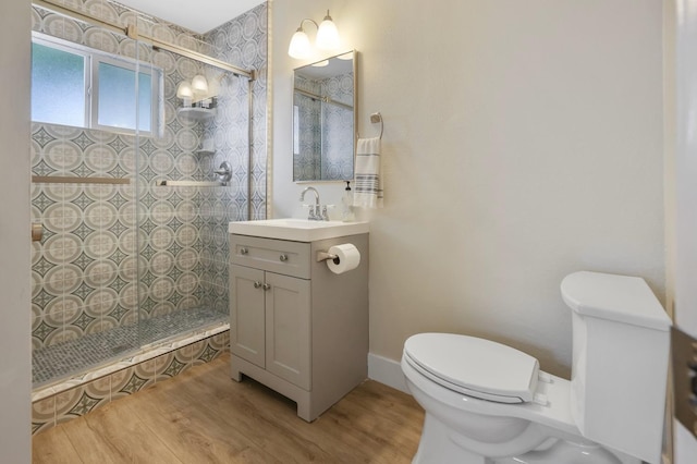 full bathroom with a walk in shower, toilet, vanity, and wood finished floors