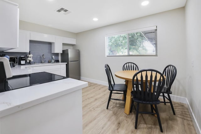 dining area featuring light wood finished floors, visible vents, recessed lighting, and baseboards