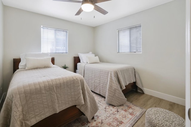 bedroom featuring light wood finished floors, ceiling fan, and baseboards