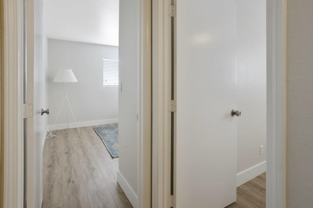 hall featuring baseboards and wood finished floors