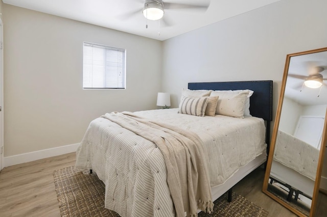 bedroom with ceiling fan, baseboards, and wood finished floors