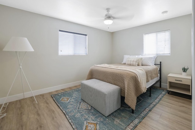 bedroom with baseboards, light wood finished floors, and ceiling fan