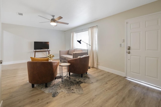 living room featuring visible vents, baseboards, and light wood-style flooring