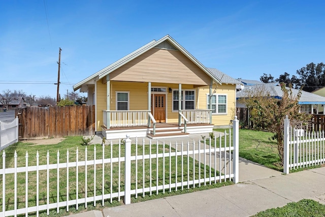 bungalow-style house featuring a porch, a front yard, and a fenced front yard