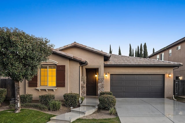 single story home featuring a garage, concrete driveway, a tile roof, fence, and stucco siding