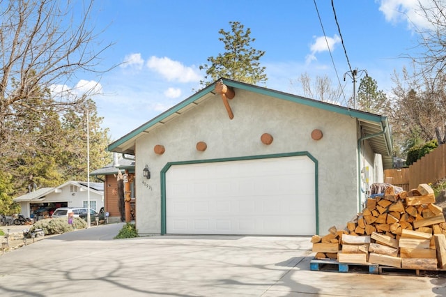 exterior space featuring concrete driveway and fence