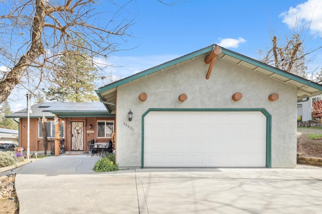 view of front of home with driveway, an attached garage, and stucco siding