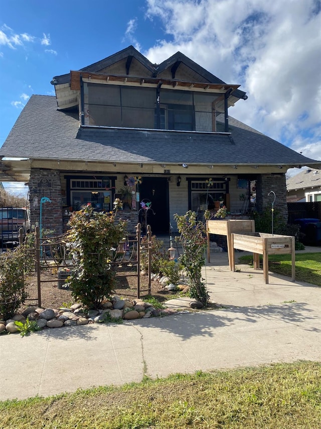 view of front of house with brick siding and roof with shingles