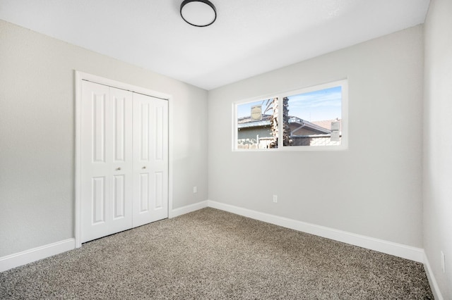 unfurnished bedroom with carpet, baseboards, and a closet