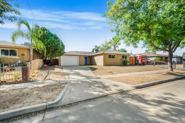 single story home with concrete driveway, fence, an attached garage, and stucco siding