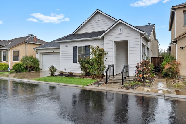 view of front of property with a garage, concrete driveway, and a shingled roof