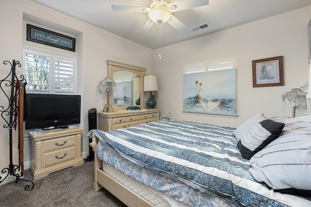 bedroom with a ceiling fan, visible vents, dark carpet, and baseboards