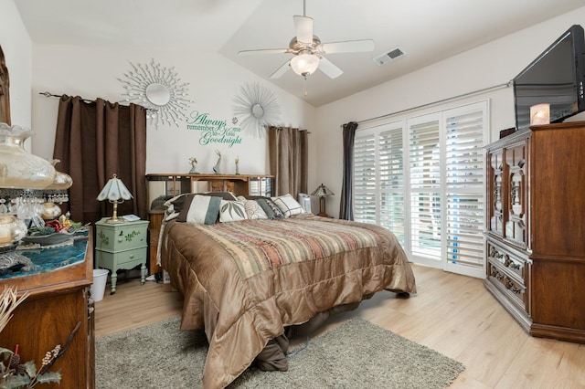 bedroom with light wood-type flooring, lofted ceiling, visible vents, and ceiling fan