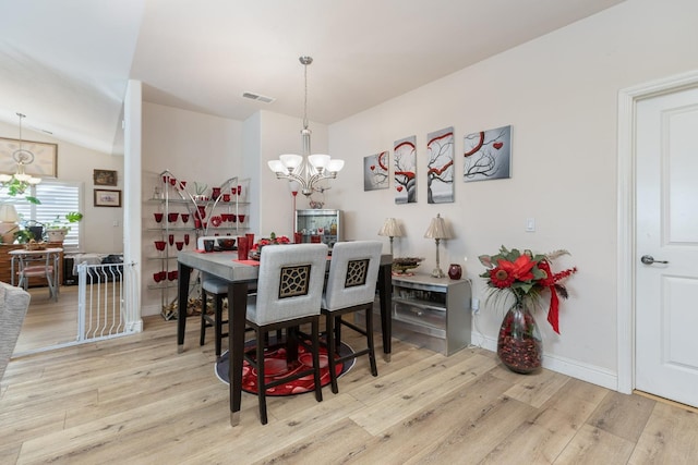 dining area featuring wood finished floors, visible vents, baseboards, and an inviting chandelier