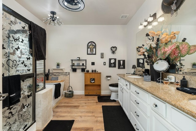 kitchen with light stone counters, a sink, visible vents, white cabinets, and light wood finished floors