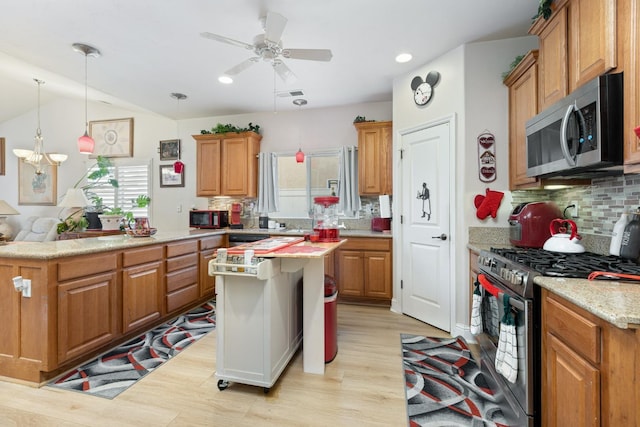 kitchen featuring light wood finished floors, visible vents, a center island, stainless steel appliances, and backsplash