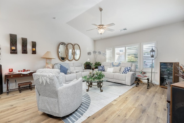 living room with vaulted ceiling, ceiling fan, light wood-type flooring, and visible vents