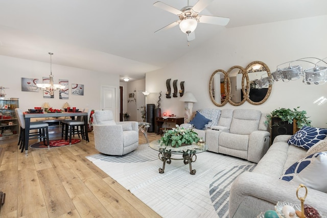 living room featuring lofted ceiling, hardwood / wood-style floors, and ceiling fan with notable chandelier