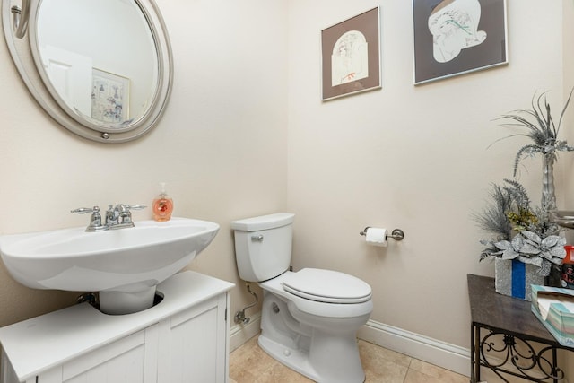 bathroom with tile patterned flooring, a sink, toilet, and baseboards