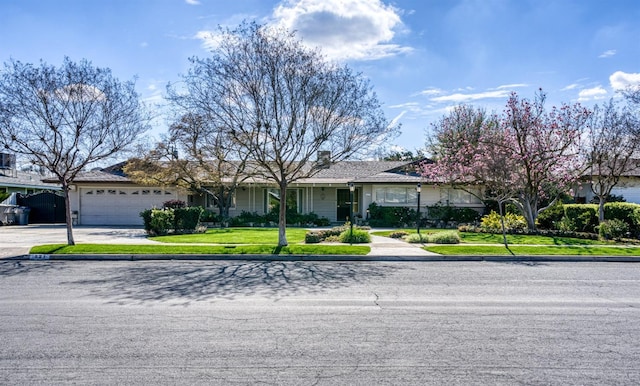 view of front of home with a garage, a front yard, and concrete driveway