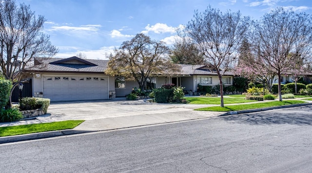 single story home featuring concrete driveway, a front lawn, and an attached garage