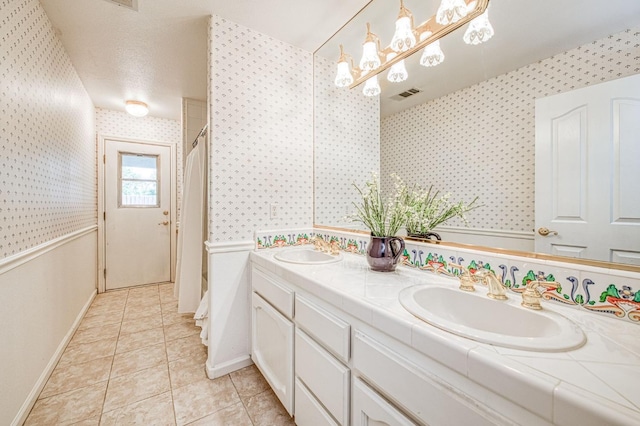 full bathroom with tile patterned floors, visible vents, a sink, and wallpapered walls