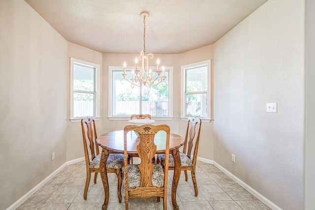 dining space featuring a notable chandelier, baseboards, and light tile patterned floors