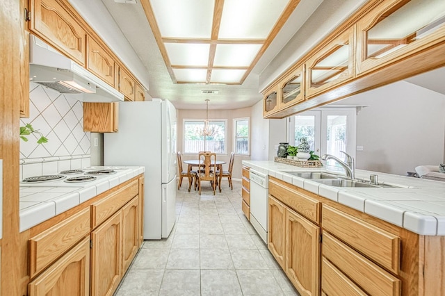 kitchen featuring tile countertops, white appliances, a sink, french doors, and tasteful backsplash