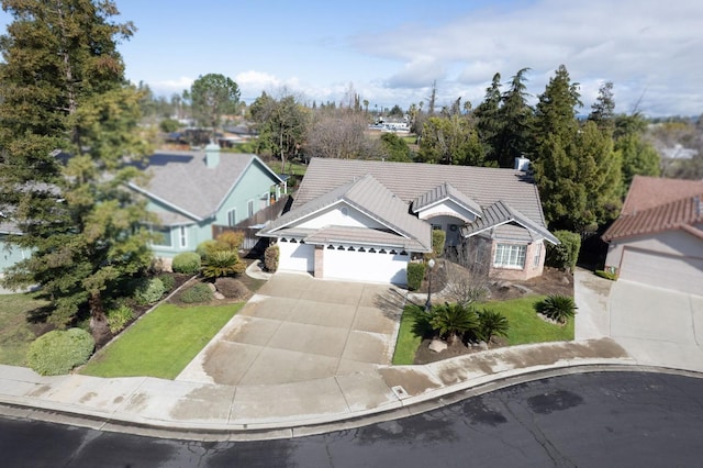 view of front facade with a garage, driveway, and a tiled roof