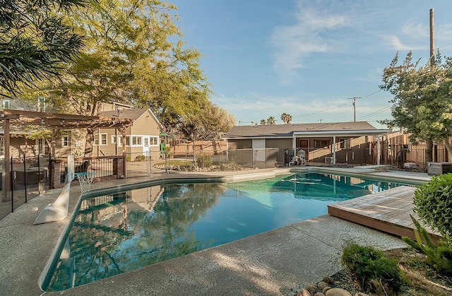 view of pool featuring a patio, central AC unit, fence, a diving board, and a fenced in pool